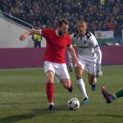 The ball stays close with a defender behind.